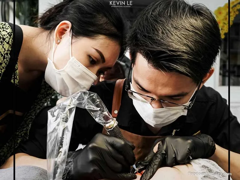 Giảng viên kèm cặp học viên thực hành kĩ thuật đi kim tại địa chỉ học phun môi Kevin Le.