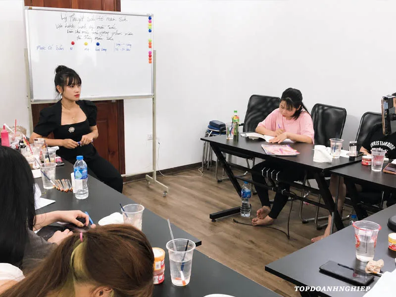 Hình ảnh học viên đang chăm chú ghi chép bài lý thuyết màu sắc, một phần quan trọng khi tìm kiếm địa chỉ học phun mí mắt chất lượng.