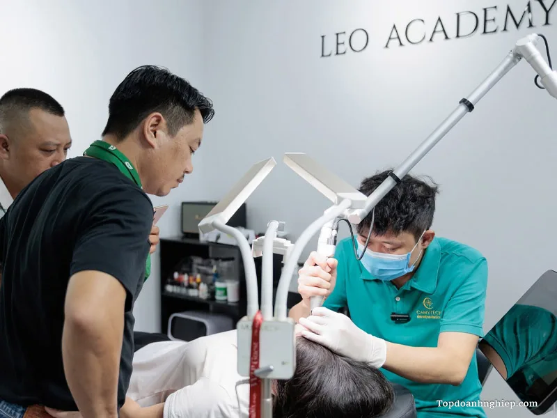 Instructor demonstrating precision hairline procedures with lighting equipment at Leo Academy