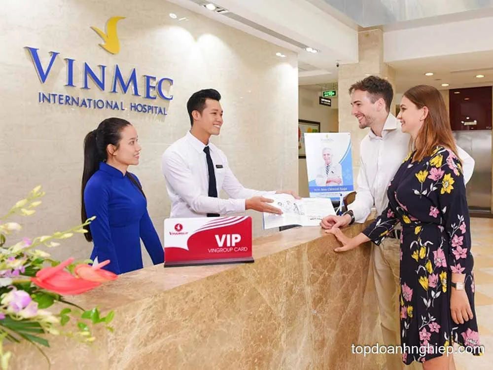 Reception staff assisting international visitors at the VIP reception counter of Vinmec International Hospital